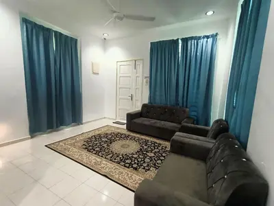 a living room with a couch and blue curtains at HOMESTAY BERTAM SAFAR in Kepala Batas