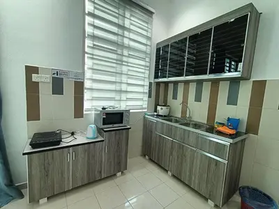 a kitchen with a sink and a microwave at HOMESTAY BERTAM SAFAR in Kepala Batas