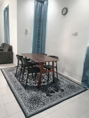 a wooden table and chairs on a rug in a living room at HOMESTAY BERTAM SAFAR in Kepala Batas