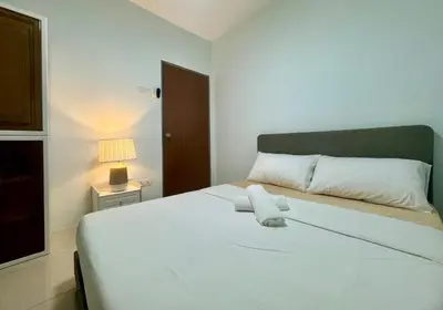 a bedroom with a large white bed with a lamp at MyStay IPOH Manhattan waterpark in Ipoh