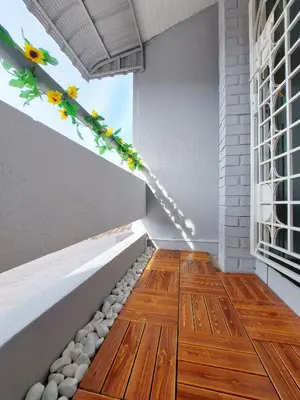 a room with a wooden floor and a flower arrangement at Decozy Ten Ipoh Bercham 13 pax Plus in Ipoh