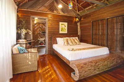 a bedroom with a bed in a wooden room at Fig Tree Hills Resort (\u82b1\u679c\u5c71\u5ea6\u5047\u6751) in Bayan Lepas