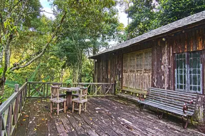 a wooden deck with a table and a bench at Fig Tree Hills Resort (\u82b1\u679c\u5c71\u5ea6\u5047\u6751) in Bayan Lepas