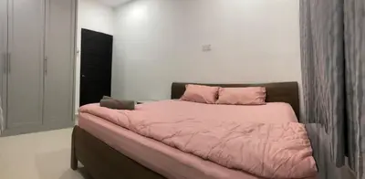 a bed with a pink comforter in a bedroom at 4 Bedrooms Semi D Homestay by Mr Homestay in Kulim