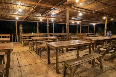 a large wooden deck with wooden tables and benches at Rain Forest Inn in Ringlet