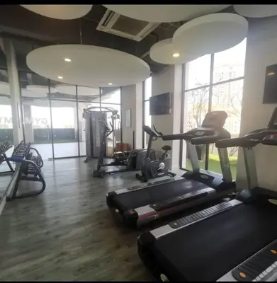 a gym with treadmills and ellipticals in a room at jazz suite 2 bedroom sea view apartment in Tanjung Bungah