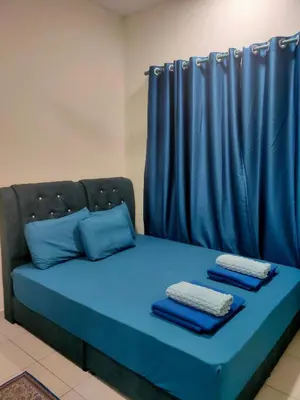 a blue bed with blue pillows and a curtain at Homestay Fayyadh Teluk Intan 3Room2Bath in Teluk Intan