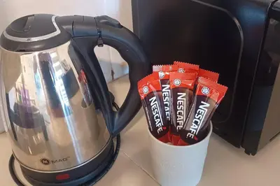 a coffee pot with packets of tea in it at Grand Suite @ The CEO Penang in Bayan Lepas