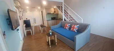 a living room with a blue couch and a staircase at Grand Suite @ The CEO Penang in Bayan Lepas