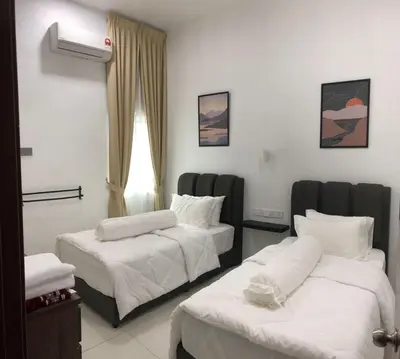 a hotel room with two beds and a window at Homestay Muslim Gunung Rapat Ipoh in Ipoh