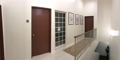a hallway with a staircase and a brown door at Homestay Muslim Gunung Rapat Ipoh in Ipoh