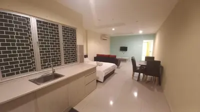 a kitchen with a sink and a bed in a room at Laguna Apartment 2, Marina Island Homestay in Kampong Batu Gajah