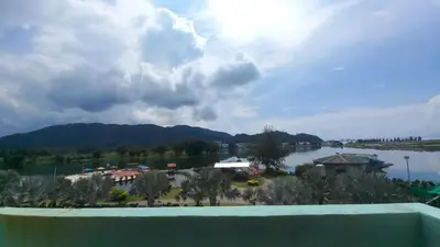 a view from the balcony of a resort with a lake and mountains at Laguna Apartment 2, Marina Island Homestay in Kampong Batu Gajah