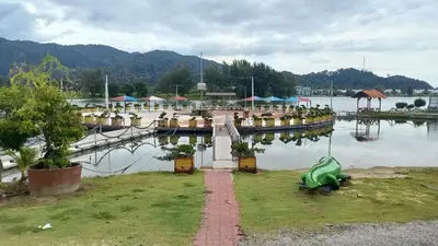 a marina with a green boat in the water at Laguna Apartment 2, Marina Island Homestay in Kampong Batu Gajah