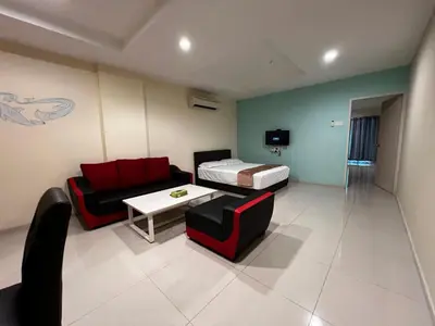 a room with a couch and a bed and a table at Laguna Apartment 2, Marina Island Homestay in Kampong Batu Gajah