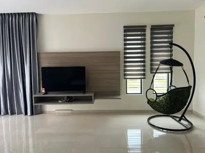 a living room with a chair and a flat screen tv at Bichrome Marina Island Private Villa Pangkor Lumut in Lumut