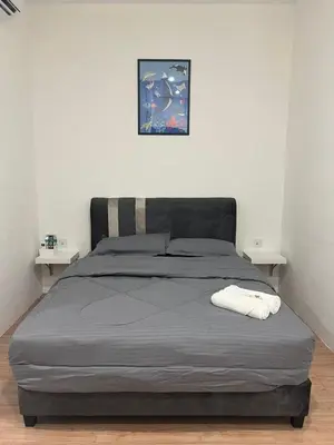 a bed in a bedroom with two white tables at KIWI INN in Taiping