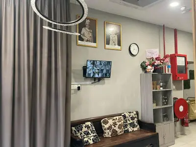 a living room with a couch and a clock at HPY Hotel in Ipoh
