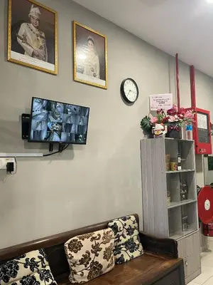 a living room with a couch and a clock at HPY Hotel in Ipoh