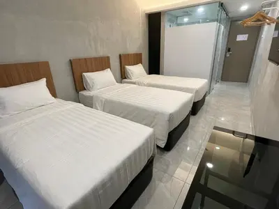 a hotel room with two beds and a shower at HPY Hotel in Ipoh