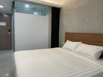 a bedroom with a large white bed with a sliding glass door at HPY Hotel in Ipoh