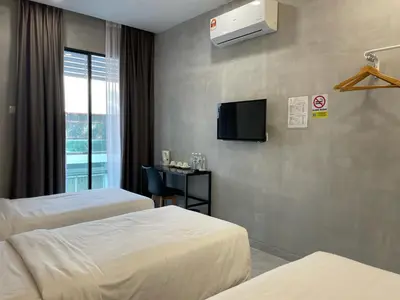 a hotel room with two beds and a flat screen tv at HPY Hotel in Ipoh