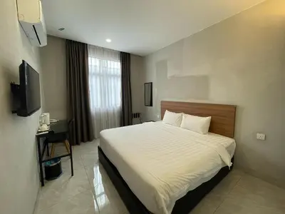 a hotel room with a bed and a television at HPY Hotel in Ipoh