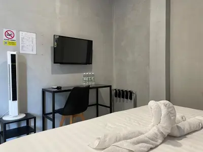 a bedroom with a bed with a tv on the wall at HPY Hotel in Ipoh