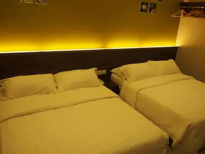 two beds in a hotel room with white sheets and pillows at Star Bay Hotel in Lumut