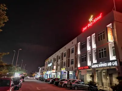 a street with cars parked in front of a building at Star Bay Hotel in Lumut
