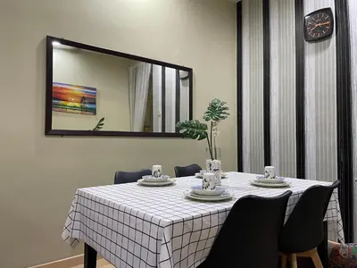 a dining room table with a white table cloth and a mirror at Myra Homestay Bertam, Penang in Kepala Batas