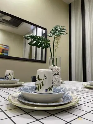 a table with two coffee cups and a potted plant at Myra Homestay Bertam, Penang in Kepala Batas