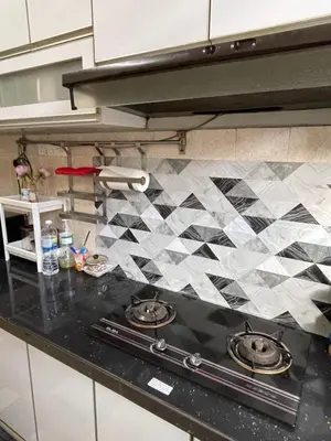 a kitchen with a black counter top with a stove at Myra Homestay Bertam, Penang in Kepala Batas