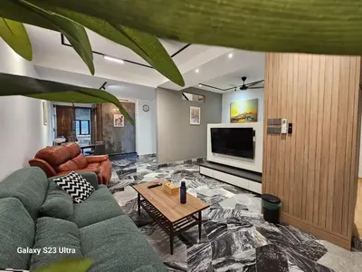 a living room with a couch and a tv at Traveler's Stay @ Ipoh (10Pax) in Ipoh