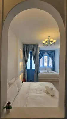 a bedroom with a white bed and a window at Ipoh Santorini Hideaway - Hotel Inspired in Ipoh