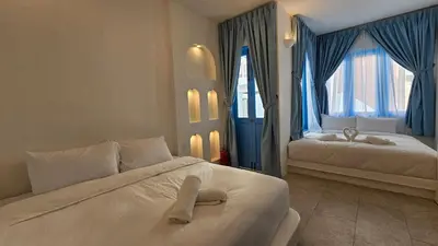a hotel room with two beds and blue curtains at Ipoh Santorini Hideaway - Hotel Inspired in Ipoh