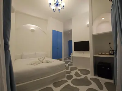 a bedroom with a white bed and a chandelier at Ipoh Santorini Hideaway - Hotel Inspired in Ipoh
