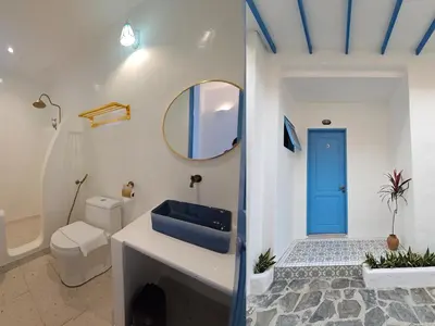a bathroom with a toilet and a blue door at Ipoh Santorini Hideaway - Hotel Inspired in Ipoh