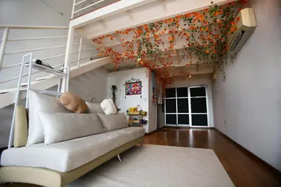 a living room with a couch and flowers on the wall at Private Zen at The CEO Bayan Lepas Penang in Bayan Lepas