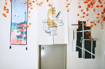 a room with a cat sitting on a toilet and posters at Private Zen at The CEO Bayan Lepas Penang in Bayan Lepas