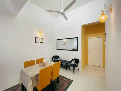 a dining room with a table and yellow chairs at WawAmir Homestay @ Seri Iskandar in Seri Iskandar