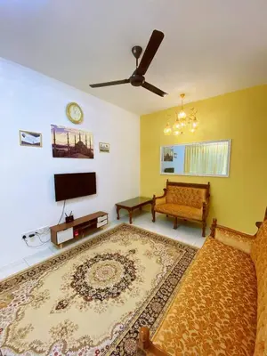 a living room with a couch and a flat screen tv at WawAmir Homestay @ Seri Iskandar in Seri Iskandar