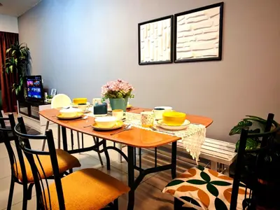 a dining room with a table and chairs with flowers on it at Ipoh City Centre Majestic 2 Room Condo near Gerbang Malam by City Home Empire in Ipoh