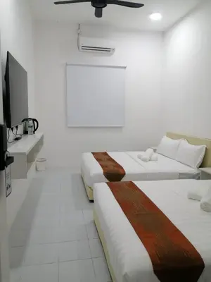 two beds in a white room with a tv at SKYN SMART HOME in Ipoh
