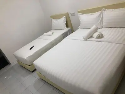 two beds in a hotel room with white sheets at SKYN SMART HOME in Ipoh
