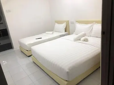 two beds in a hotel room with white sheets at SKYN SMART HOME in Ipoh