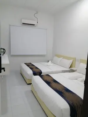 two beds in a room with white walls and white floors at SKYN SMART HOME in Ipoh