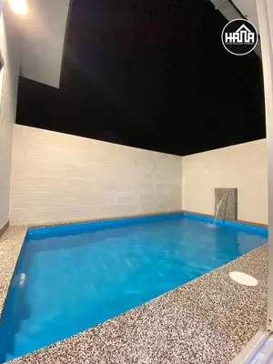 a large swimming pool with blue water in a room at Rumah Hana Sekinchan - Mslim0nly in Sekincan