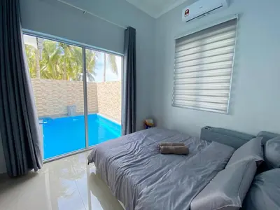 a bedroom with a bed with a view of a pool at Rumah Hana Sekinchan - Mslim0nly in Sekincan
