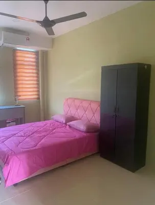 a bedroom with a pink bed and a cabinet at Jentayu homestay in Seri Iskandar